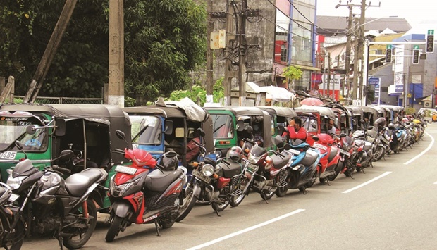 Motorists queue along a street to buy fuel at a Ceylon Petroleum Corporation fuel station in Colombo yesterday.