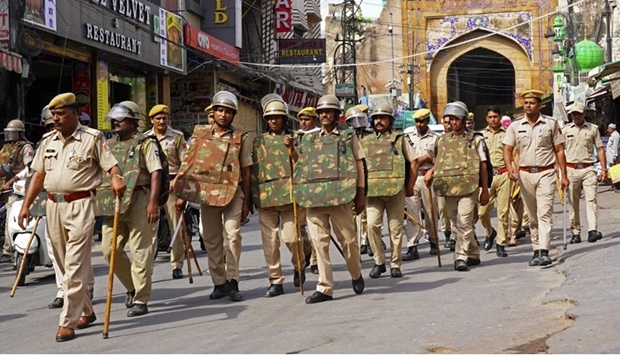 Policemen carry out a flag march through a street in Ajmer on June 29, 2022, following the alleged murder of a Hindu tailor by two Muslim men in Udaipur.