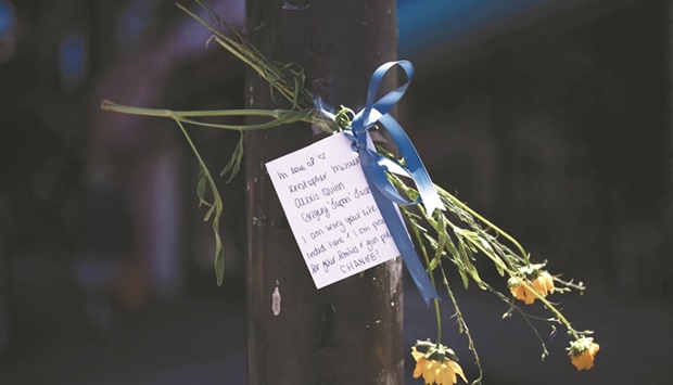 A note and flowers honouring the victims of a mass shooting in South Philadelphia are taped to a traffic light post at the corner of South and Third Streets in Philadelphia, Pennsylvania yesterday. (AFP)