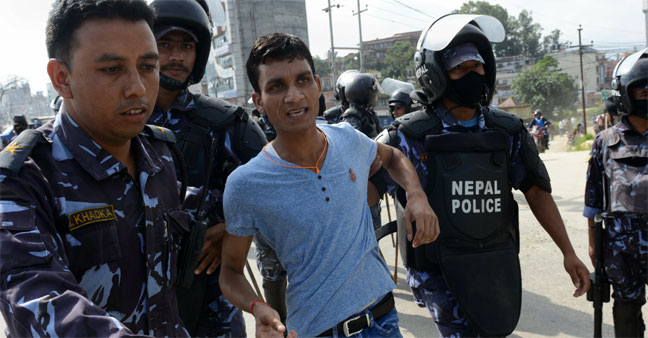 Nepalese police arrest an opposition supporter during a general strike 