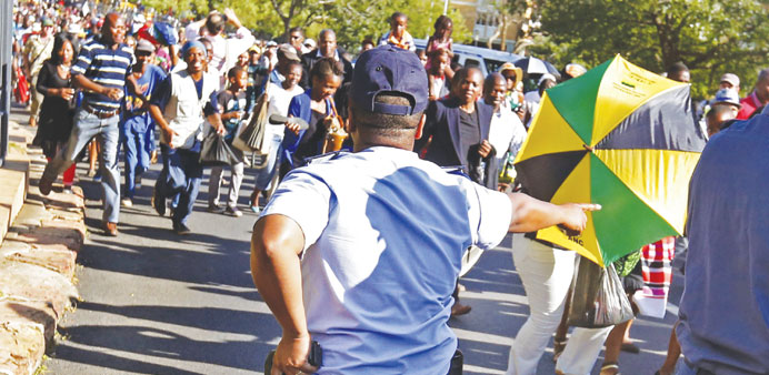 A tense moment as a police officer confronts mourners who broke through police barriers to head for the Union Buildings in Pretoria to view the body o