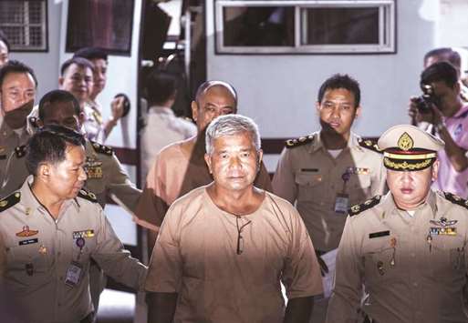 Lieutenant General Manas Kongpan is escorted by officers at the criminal court in Bangkok.