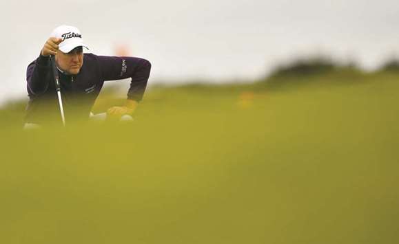 Englandu2019s Ian Poulter lines up putt on the 9th green during his opening round on the first day of the Open Golf Championship at Royal Birkdale golf course near Southport in north west England yesterday.