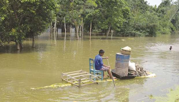 A man rows a raft made of banana tree trunks on floodwater in Sirajganj, 130km from Dhaka.