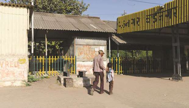 (FILES) In this photograph taken on March 20, 2014, (FILES) In this photograph taken on March 20, 2014, Indian pedestrians walk past the former tea stall (C) of Damodardas Mulchand Modi, father of Prime Minister Narendra Modi and where Modi assisted his father in his spare time, is pictured at the railway station in Vadnagar, some 110 kms from Ahmedabad. Now it is rusting hulk in a small town railway station, but Indian authorities want the stall where Prime Minister Narendra Modi sold tea with his father to become a global tourist magnet.