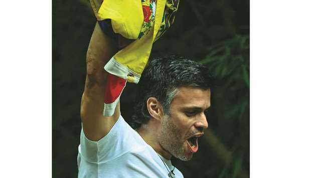 Venezuelan opposition leader Leopoldo Lopez displays a Venezuelan national flag as he greets supporters gathering outside his house in Caracas, after he was released from prison and placed under house arrest for health reasons yesterday.
