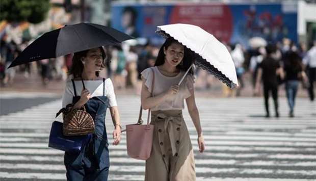 Women shield themselves from the sun with umbrellas in Tokyo on Tuesday.