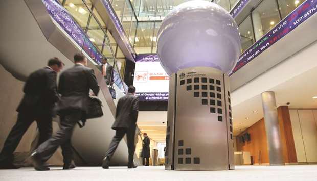 Visitors pass a sign inside the London Stock Exchange (file). The FTSE 100 closed up 0.5% to 7,701.31 points yesterday.