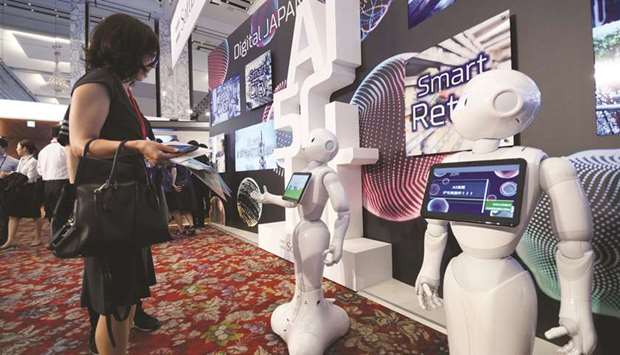 A visitor interacts with a SoftBank Groupu2019s Pepper humanoid robot during the SoftBank World 2019 event in Tokyo. The Japanese firm has secured pledges from Microsoft and other investors of around $108bn for a second Vision Fund aimed at investing in technology firms.