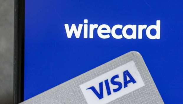 A Visa credit card rests on an Apple iPhone X smartphone displaying the Wirecard payment app launch screen in this arranged photograph in Frankfurt. The fintech firm filed for court protection from creditors in Germany last week following revelations that u20ac1.9bn ($2.1bn) was missing from its balance sheet.