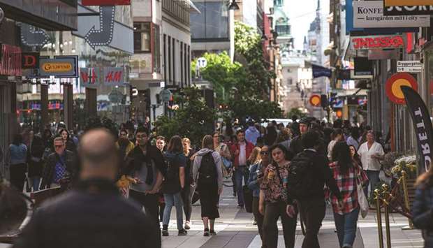 People walk in Drottninggatan during rush hour in Stockholm, amid the coronavirus Covid-19 pandemic.