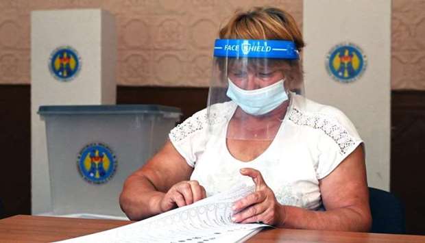 A member of a local electoral commission counts ballots in a polling station in the village of Valea-Trestieni, some 85 km north of Chisinau, on July 10