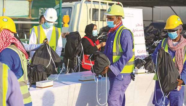 Workers at the new bus station construction project in Al-Wakra receive hygiene kits.