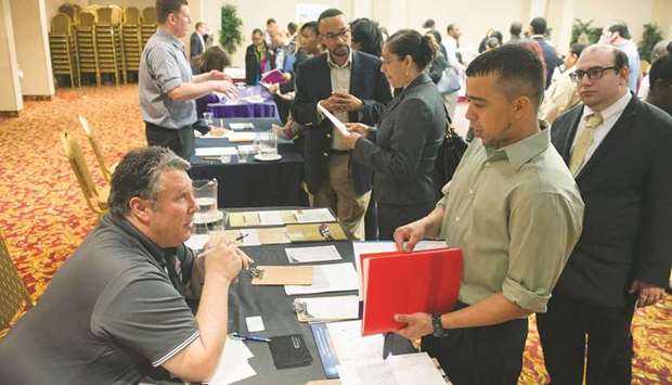 A recruiter talks with a job seeker at a career fairs in New York (file). Nonfarm payrolls in the US increased by 850,000 last month, bolstered by strong job gains in leisure and hospitality, a Labour Department report showed yesterday.