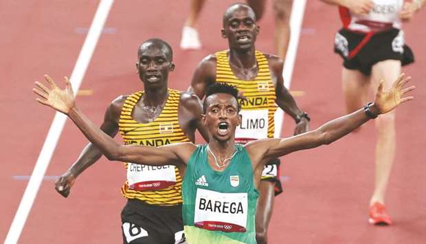 Ethiopiau2019s Selemon Barega (centre) celebrates after winning ahead of second-placed Ugandau2019s Joshua Cheptegei (left) and third-placed Ugandau2019s Jacob Kiplimo (right) in the menu2019s 10,000m final at the Tokyo 2020 Olympic Games in Tokyo on Friday. (AFP)