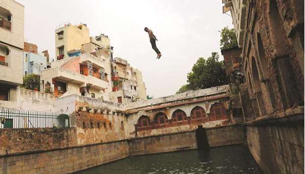 A boy jumps into a stepwell to cool off on a hot summer day in New Delhi, India, yesterday.