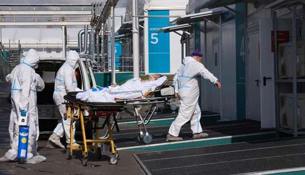 Medical specialists wearing protective gear transport a person on a stretcher outside a hospital for patients infected with the coronavirus disease (Covid-19) on the outskirts of Moscow, Russia