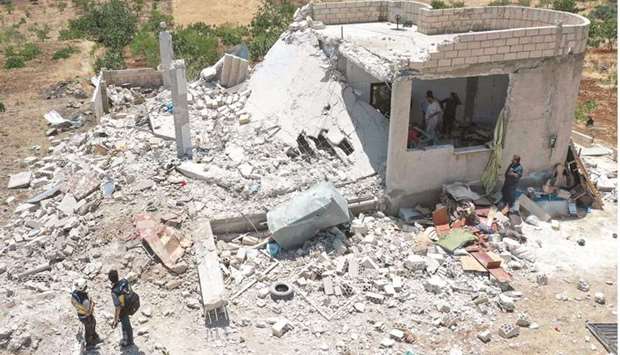 An aerial picture shows people salvaging items from the rubble of a damaged house following reported regime shelling in Jabal al-Zawiyau2019s Balyun village, in the south of Syriau2019s last major rebel stronghold of Idlib in the countryu2019s northwest, yesterday.