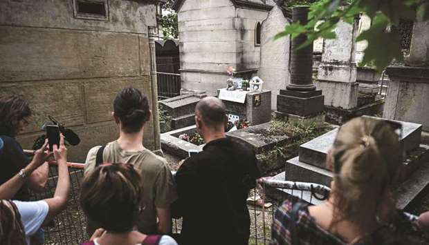 People gather by the grave of The Doors frontman Jim Morrison to commemorate the 50th  anniversary of his death at the Pere Lachaise cemetery in Paris yesterday. (AFP)