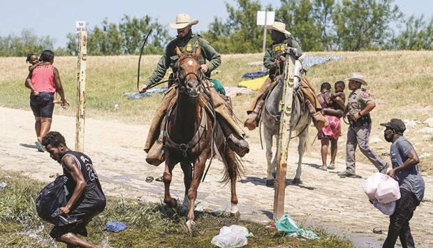 In this file photo taken on September 19, 2021, US Border Patrol agents on horseback try to stop Haitian migrants from entering an encampment on the banks of the Rio Grande, near the Acuna Del Rio International Bridge in Del Rio, Texas.