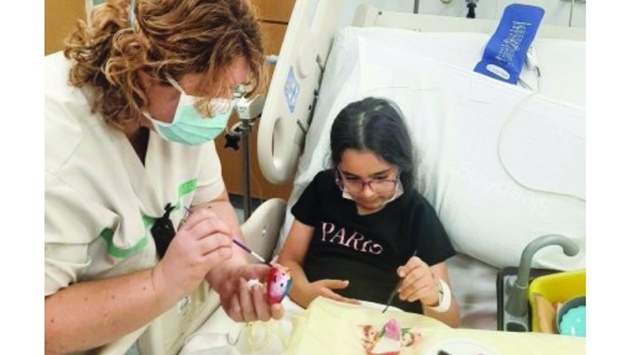 Michelle Dixon comforting a child patient with art therapy