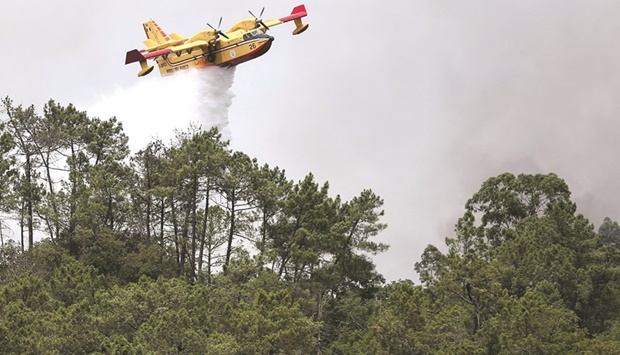 A firefighting aircraft works to contain a forest fire in Leiria, Portugal, on Thursday.