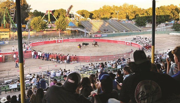 Spectators watch Portuguese-style bloodless bullfights hosted by the Turlock Pentecost Association at the Stanislaus County Fairgrounds in Turlock, California.