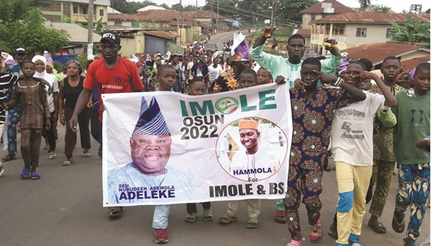 Supporters march with a banner to celebrate the victory of the candidate of the opposition Peoples Democratic Party (PDP), Ademola Adeleke, following the conclusion of the gubernatorial election at Ido Osun, Oshun State in southwest Nigeria, yesterday.