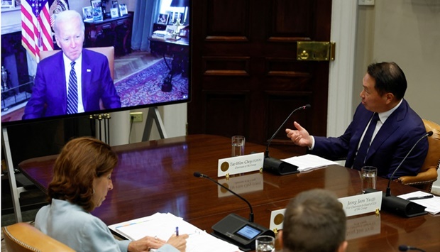US President Joe Biden, with Commerce Secretary Gina Raimondo, meets virtually with a delegation from SK Group led by Chairman Chey Tae-won from the Roosevelt Room at the White House in Washington yesterday. (Reuters)
