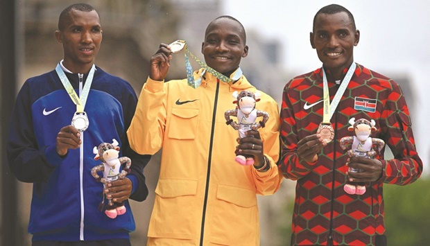 Silver-medallist Tanzaniau2019s Alphonce Felix Simbu (left), gold-medallist Ugandau2019s Victor Kiplangat (centre) and bronze-medallist Kenyau2019s Michael Mugo Githae pose with their medals during the presentation ceremony for the menu2019s marathon on day two of the Commonwealth Games at Smithfield in Birmingham, central England, yesterday. (AFP)