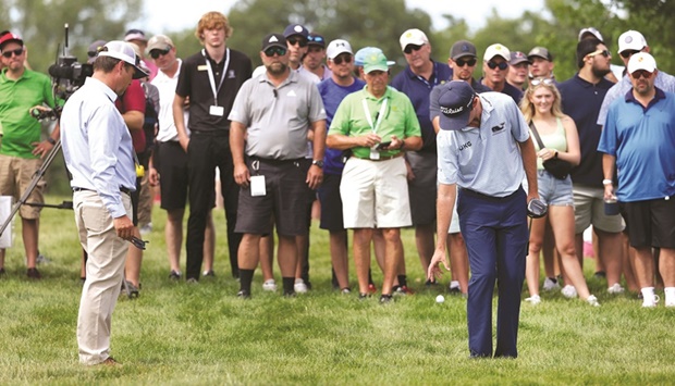 J T Poston of the US talks with a rules official about the lie of his ball on the 15th hole during the third round of the John Deere Classic at TPC Deere Run in Silvis, Illinois. (AFP)