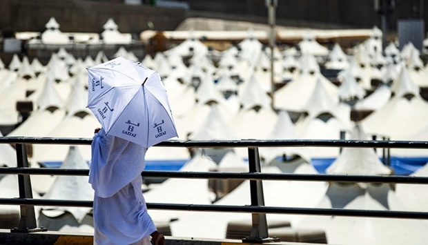 A pilgrim walks with an umbrella at the camp in Mina near Makkah yesterday during the annual Haj pilgrimage. 