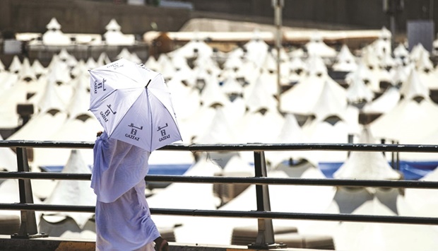 A pilgrim walks with an umbrella at the camp in Mina near Makkah yesterday during the annual Haj pilgrimage. (AFP)