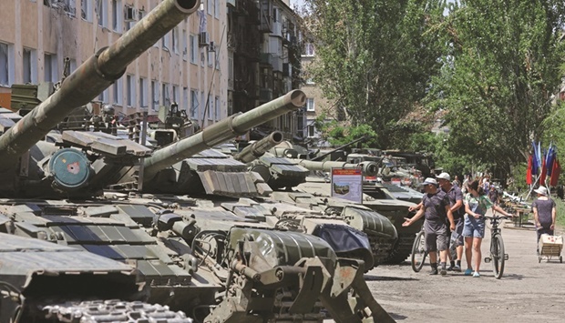 Local residents view Ukrainian army hardware and weapons left in Lysychansk city in Luhansk region, after its withdrawal during Ukraine-Russia conflict.