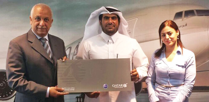 Hamad al-Naimi receiving the grand prize of 1mn Qmiles from Ehab Amin.