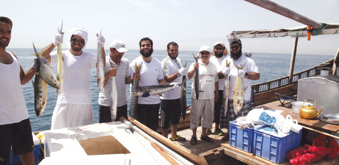 Crew members of a competing dhow show off their catch.