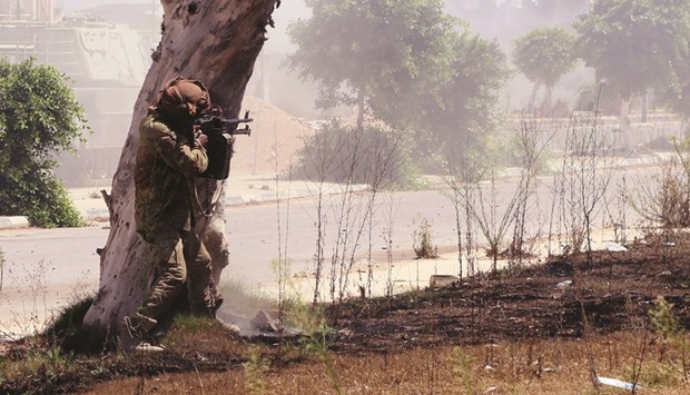 A member of forces loyal to Libyau2019s UN-backed Government of National Accord (GNA), aims his weapon in al-Zaafaran neighbourhood as pro-government forces fight with Islamic State group (IS) fighters holed up in residential district two yesterday in Sirte.