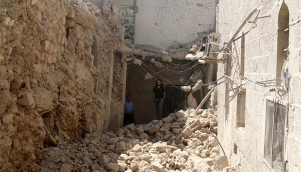 Residents inspect their damaged homes after an airstrike on the rebel-held Old Aleppo on Monday.