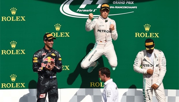 Mercedes AMG Petronas F1 Team's German driver Nico Rosberg (C) celebrates winning next to second placed Red Bull Racing's Australian driver Daniel Ricciardo and third placed Mercedes AMG Petronas F1 Team's British driver Lewis Hamilton