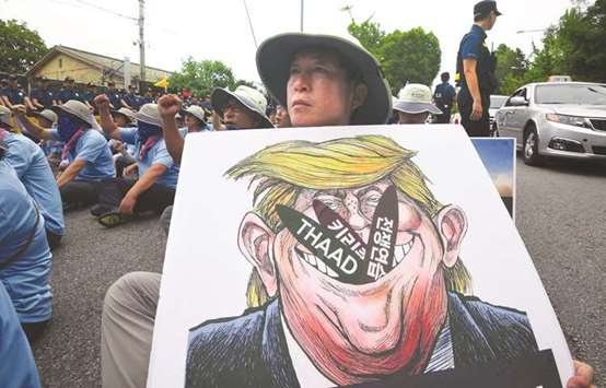 A South Korean protester holds a placard showing a caricature of US President Donald Trump during an anti-US rally.