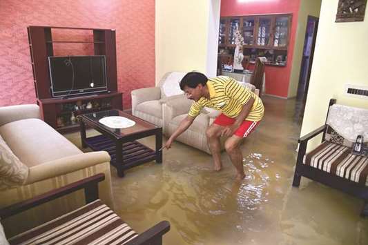 A man looks for a lost item in his flooded house situated in a low-lying area in Bengaluru yesterday.