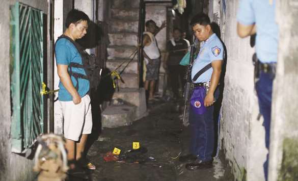 Policemen at the scene after three men were killed during a police anti-drug operations in Caloocan city, Metro Manila.