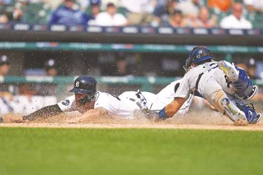 Detroit Tigers center fielder JaCoby Jones (left) slides safely into home plate as Los Angeles Dodgers catcher Austin Barnes attempts the tag during an MLB game on Sunday. (USA TODAY Sports)