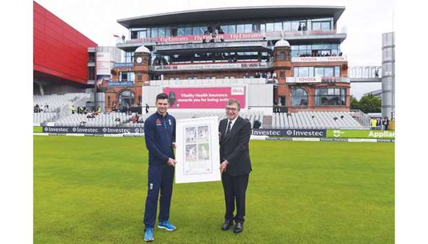 Lancashire County Cricket Club Chairman David Hodgkiss (right) presents a portrait to England fast bowler James Anderson at the Old Trafford Cricket Ground in Manchester yesterday. (AFP)