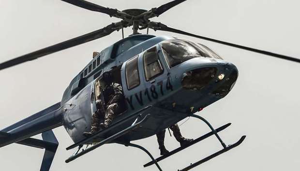 Security forces in a helicopter fly over the Venezuelan city of Valencia