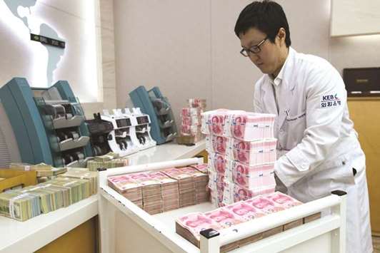 An employee arranges yuan banknotes at the Korea Exchange Bank headquarters in Seoul. The offshore yuan, or CNH, dropped 0.34% to 6.8454 per dollar yesterday in Hong Kong.