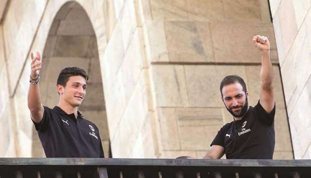 AC Milanu2019s new players Argentinian Gonzalo Higuain (R) and Italian Mattia Caldara acknowledge the fans from a balcony in Milanu2019s central Piazza Duomo square yesterday. (AFP)