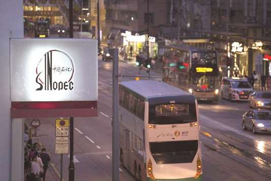 Signage for a Sinopec gas station stands illuminated next to a road at dusk in Hong Kong (file). China took 15mn barrels of US crude in June, the most in data going back to 1996, according to US Census Bureau and Energy Information Administration.