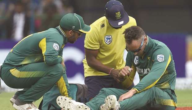 South African cricket team captain Faf du Plessis (R) reacts after injuring himself  during the third One Day International against  Sri Lanka in Pallekele on August 5.