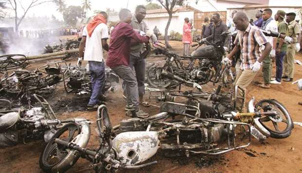 Rescuers remove burnt motorbikes from the scene where a fuel tanker exploded killing a crowd of people collecting liquid from puddles in jerricans in Morogoro, eastern Tanzania yesterday.